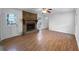 Sunlit living room with hardwood floors, a stone fireplace, and a door leading to the outside, offering warmth and scenic views at 8005 Bamby Ln, Jonesboro, GA 30236