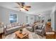 Bright, virtually staged living room features hardwood floors, neutral furniture, a ceiling fan, and large windows for ample natural light at 8005 Bamby Ln, Jonesboro, GA 30236