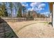 Large, fenced backyard featuring dormant grass and mature trees in a desirable neighborhood at 116 Holly View Ln, Canton, GA 30114