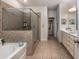 Spacious bathroom featuring a glass-enclosed shower, bathtub, double vanity, and tile flooring leading to walk-in closet at 116 Holly View Ln, Canton, GA 30114