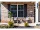 Inviting front porch with seating area, decorative plants, and stylish brickwork and shutters at 116 Holly View Ln, Canton, GA 30114