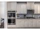 Modern kitchen features stainless steel appliances, granite countertops, and white cabinetry at 116 Holly View Ln, Canton, GA 30114