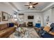 Bright living room featuring a fireplace, ceiling fan, and comfortable seating with a stylish blue patterned rug at 116 Holly View Ln, Canton, GA 30114