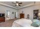 Spacious primary bedroom featuring a tray ceiling, ceiling fan, dresser, and bedroom access to en-suite bathroom and walk-in closet at 116 Holly View Ln, Canton, GA 30114