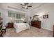Comfortable bedroom featuring a tray ceiling, ceiling fan, and dresser; a well-lit space with neutral decor at 116 Holly View Ln, Canton, GA 30114