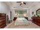 Well-lit primary bedroom featuring a tray ceiling, ceiling fan, and ample storage with dresser; a serene and comfortable retreat at 116 Holly View Ln, Canton, GA 30114