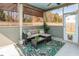 Inviting screened porch with outdoor seating, ceiling fan, and a stylish leaf-patterned rug at 116 Holly View Ln, Canton, GA 30114