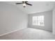 Bright bedroom featuring neutral walls, plush gray carpet, ceiling fan, and a large window at 3374 Thornbridge Dr, Powder Springs, GA 30127