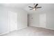 Bright bedroom featuring neutral walls, plush gray carpet, ceiling fan, and two doors at 3374 Thornbridge Dr, Powder Springs, GA 30127
