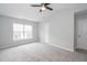 Bright bedroom featuring neutral walls, plush gray carpet, ceiling fan, and a large window at 3374 Thornbridge Dr, Powder Springs, GA 30127