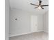 Bright bedroom featuring neutral walls, plush gray carpet, ceiling fan, and a door at 3374 Thornbridge Dr, Powder Springs, GA 30127