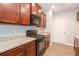 Modern kitchen featuring wood cabinets, granite countertops, and stainless steel appliances at 3374 Thornbridge Dr, Powder Springs, GA 30127