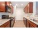 Galley kitchen featuring wood cabinets, granite countertops, and stainless steel appliances at 3374 Thornbridge Dr, Powder Springs, GA 30127