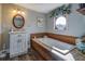 Bathroom featuring tub with wood surround and unique round window and granite vanity at 885 Malcom Rd, Covington, GA 30014