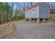Backside view of the gray house, with red roof, on stilts and a parking area at 885 Malcom Rd, Covington, GA 30014