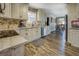 Cozy kitchen with stainless steel appliances, granite counters, distressed white cabinetry and wood-look flooring at 885 Malcom Rd, Covington, GA 30014