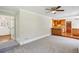 Open-concept living room featuring gray carpet, ceiling fan, and view into kitchen with wood cabinets at 860 Valleymeade Se Dr, Marietta, GA 30067