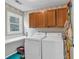 Laundry room with white washer and dryer and overhead cabinets at 1293 Wynford Colony Sw, Marietta, GA 30064