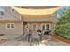 Covered outdoor dining area with modern furniture, string lights, and wooded views at 1293 Wynford Colony Sw, Marietta, GA 30064