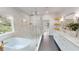 Modern bathroom featuring a soaking tub, glass shower, and double vanity with gold fixtures and shelving at 1533 Grayson Pkwy, Grayson, GA 30017