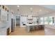 Spacious kitchen featuring white cabinets, an island with seating, modern lighting, and stainless steel appliances at 1533 Grayson Pkwy, Grayson, GA 30017