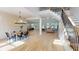 Open-concept living space with hardwood floors, staircase, large windows, and modern chandelier with views to the kitchen at 1533 Grayson Pkwy, Grayson, GA 30017