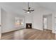 Bright living room with a modern ceiling fan and a cozy fireplace, complemented by luxury vinyl flooring at 1602 Bar J Rd, Temple, GA 30179