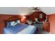 A bedroom under a sloped roof with carpet flooring, a queen bed, a dresser and cushioned chairs at 3068 River Oak Rd, Decatur, GA 30034