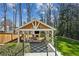 View of backyard cabana with fireplace, outdoor seating, and manicured lawn at 3125 Peachtree Ne Dr, Atlanta, GA 30305