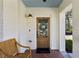 Charming front porch with stylish wreath on front door, seating, and brick flooring at 3125 Peachtree Ne Dr, Atlanta, GA 30305