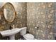 Charming powder room featuring patterned wallpaper, a pedestal sink, and an oval mirror at 3125 Peachtree Ne Dr, Atlanta, GA 30305