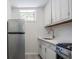 Kitchen with stainless steel refrigerator and range, white cabinetry, window and countertops at 1007 S Candler St, Decatur, GA 30030