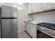 Compact kitchen with stainless steel refrigerator and range, white cabinetry and countertops at 1007 S Candler St, Decatur, GA 30030