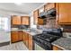 Well-lit kitchen with tile floors, granite countertops, wooden cabinets, and stainless steel appliances at 1269 Lawndale Ct, Decatur, GA 30032