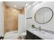 Bathroom featuring marble countertop, round mirror, tile surround bathtub and modern vanity at 2828 Peachtree Nw Rd # 1701, Atlanta, GA 30305