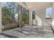 A covered back patio with a white brick pillar with a railing overlooking a backyard with trees at 52 25Th Nw St, Atlanta, GA 30309