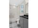 Bright bathroom featuring a shower-tub combination, patterned tile floor, and gray vanity at 52 25Th Nw St, Atlanta, GA 30309