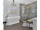 Elegant bathroom featuring a soaking tub, chandelier, and glass-enclosed shower with bench at 577 Alexander Farms Sw Vw, Marietta, GA 30064