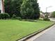 Front yard with a neatly manicured lawn, mature tree, and attractive landscaping at 577 Alexander Farms Sw Vw, Marietta, GA 30064