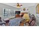 Cozy living room featuring a brick fireplace, ceiling fan, and a large window with a view of the outdoors at 577 Alexander Farms Sw Vw, Marietta, GA 30064