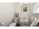 Compact bathroom features a pedestal sink, toilet, and window offering natural light in a minimalist setting at 1147 Longshore Dr, Decatur, GA 30032