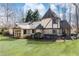 Serene backyard featuring lush green grass and a charming Tudor-style home with ample windows at 4210 Gatewood Ln, Peachtree Corners, GA 30097