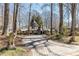 Scenic driveway flanked by lion statues approaching a charming Tudor-style home with lush landscaping at 4210 Gatewood Ln, Peachtree Corners, GA 30097