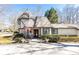 Charming Tudor-style home with a stone turret, featuring a well-manicured lawn and mature landscaping at 4210 Gatewood Ln, Peachtree Corners, GA 30097