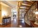 Welcoming foyer featuring hardwood floors, elegant staircase, and stone accent wall at 4210 Gatewood Ln, Peachtree Corners, GA 30097