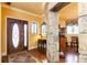 Beautiful foyer showcasing hardwood floors, a statement stone wall, and a decorative front door for a lasting first impression at 4210 Gatewood Ln, Peachtree Corners, GA 30097