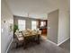 Dining room featuring neutral walls, a dining table set for six, and an adjacent kitchen at 4369 Estate St, South Fulton, GA 30349