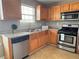 Cozy kitchen featuring stainless steel appliances, wood cabinets, and granite countertops at 4369 Estate St, South Fulton, GA 30349