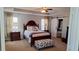 Tranquil bedroom with a king bed, tray ceiling, dark furniture, and a sliding barn door to the bathroom at 4402 Alysheba Dr, Fairburn, GA 30213