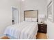 Cozy bedroom featuring hardwood floors, a queen bed, and a nightstand with a lamp at 1284 To Lani Path, Stone Mountain, GA 30083